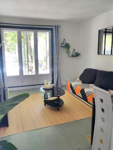 un salon avec un lit et une table dans l'établissement T2 centre-ville, appart avec balcon plein sud, 1 chambre, 2 pers, climatisation, wifi, parking public gratuit, à Lorient