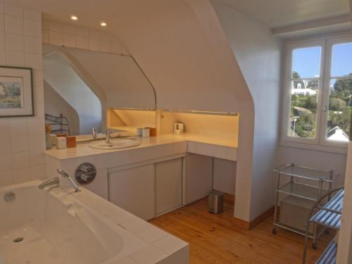 une salle de bain avec un lavabo, une baignoire et un miroir dans l'établissement Maison au bord de mer avec jardin paysager, proche port et commerces à Sauzon - FR-1-418-49, à Sauzon