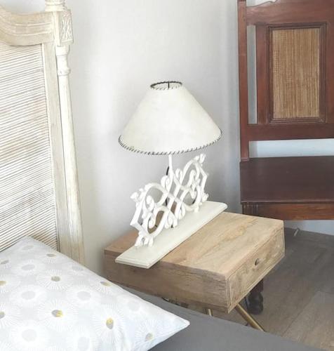 a white lamp on a table next to a bed at Cosy flat in a quiet location with free parking in Nitra