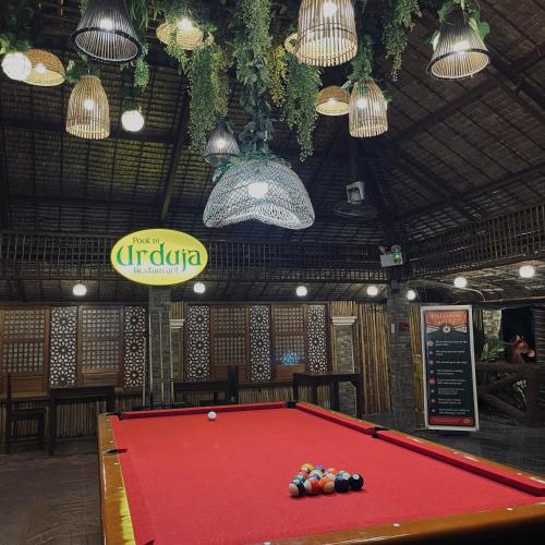 a pool table in a room with a sign and lights at Pook ni Urduja Resort 