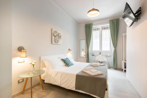 Un dormitorio blanco con una cama y una mesa. en Winkler Suites, en Roma