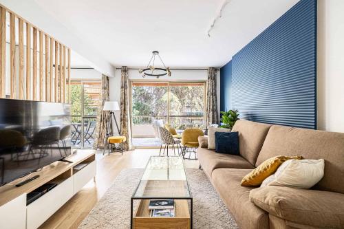 un salon avec un canapé et une télévision dans l'établissement LE FLEURI avec terrasse, à côté du Martinez, idéal pour un séjour plaisant, à Cannes