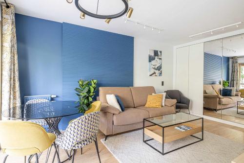 un salon avec un canapé et un mur bleu dans l'établissement LE FLEURI avec terrasse, à côté du Martinez, idéal pour un séjour plaisant, à Cannes