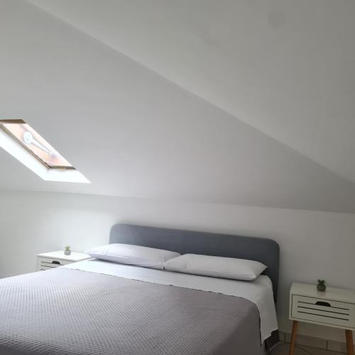 a white bedroom with a bed with two pillows at Gate 25 in San Giovanni Teatino