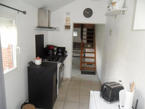 une cuisine avec un réfrigérateur noir et une cuisinière dans l'établissement Le clos des tracteurs d'antan, à Fontaine-sous-Montdidier