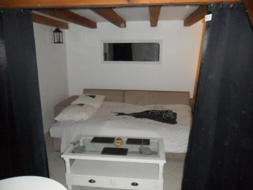 a small bedroom with a bed with a table at Le clos des tracteurs d'antan in Fontaine-sous-Montdidier