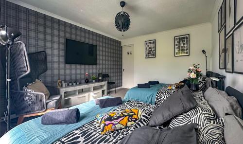 a bedroom with two beds and a flat screen tv at Brand New Scotland home 3rooms near Glasgow in Clydebank