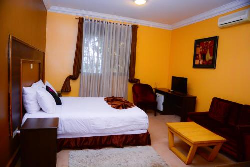a hotel room with a bed and a couch at The Country Inn Hotel in Kigali