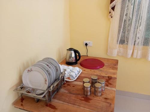 a room with a table with plates and a kettle at Grace Homestay in Benaulim