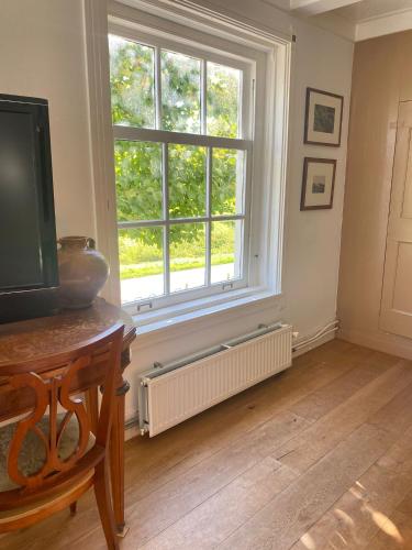 a living room with a large window and a television at Beautiful renovated Farmhouse in Ankeveen