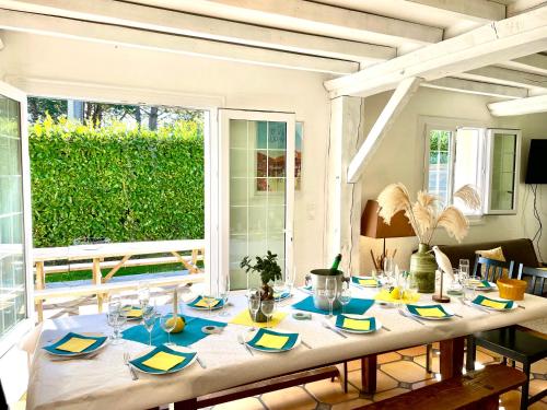 une salle à manger avec une table et une grande fenêtre dans l'établissement GITE 4 MN DE LA mer et cabourg, cheminée, table de ping pong, balançoire, à Varaville
