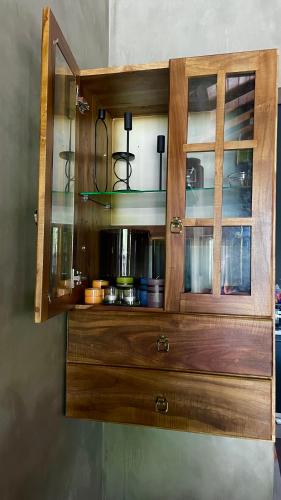 a wooden cabinet with glass doors on a wall at Negombo Morawala Beach Villa in Negombo