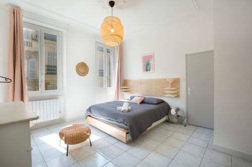 une chambre avec un lit, une chaise et des fenêtres dans l'établissement SAINTE - Vieux Port - Opéra, à Marseille