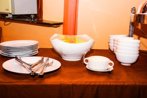 a table with plates and cups on a table at The Country Inn Hotel in Kigali