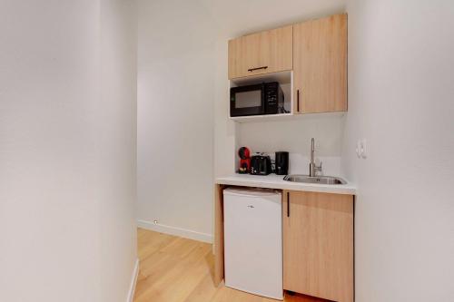 une petite cuisine avec un évier et un micro-ondes dans l'établissement Modern studio - 2P - Canal Saint Martin, à Paris
