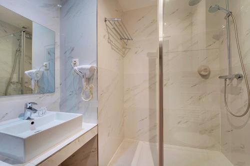 une salle de bain blanche avec un lavabo et une douche dans l'établissement Modern studio - 2P - Canal Saint Martin, à Paris