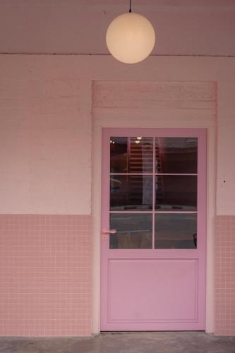 a pink door on a pink wall with a lamp at Pink Cabana Hotel in George Town