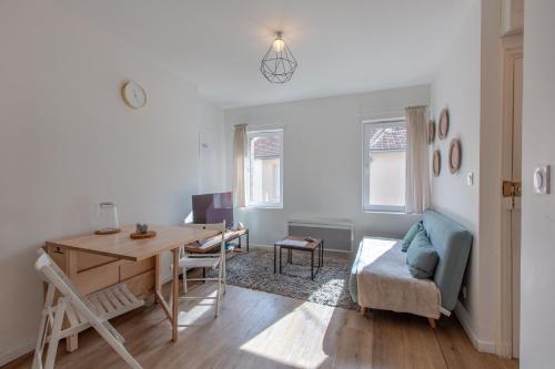 un salon avec une table et un bureau dans l'établissement Le petit Romo - Entre châteaux et Beauval, à Romorantin-Lanthenay