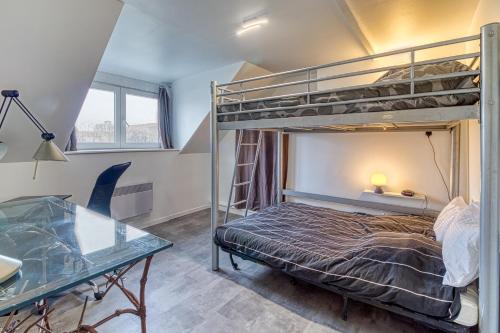 une chambre avec un lit superposé et un bureau dans l'établissement Le Majestin - Appt 6p Calais centre, à Calais