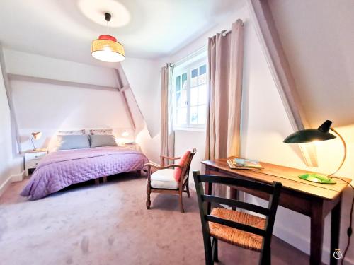 - une chambre avec un lit violet et un bureau dans l'établissement La Chaumière du Vallon -Piscine- Pont-l'Évêque 8P, à Vieux-Bourg