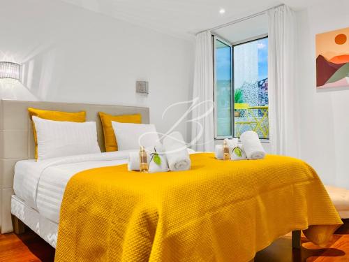 une chambre avec un lit avec une couverture jaune dans l'établissement Le Belge Croisette - Centre Cannes Palais, à Cannes