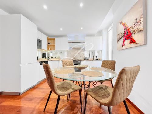une cuisine et une salle à manger avec une table et des chaises en verre dans l'établissement Le Belge Croisette - Centre Cannes Palais, à Cannes