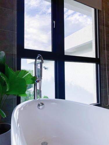 a bath tub in a bathroom with a window at Still Hills Inn in Hengchun