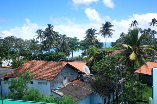 a group of houses with palm trees in the background at Villa Mathe in Dickwella