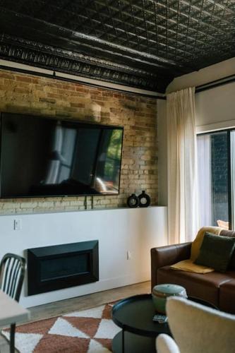 a living room with a couch and a flat screen tv at Unit B, The Kroger Lofts in Charlevoix