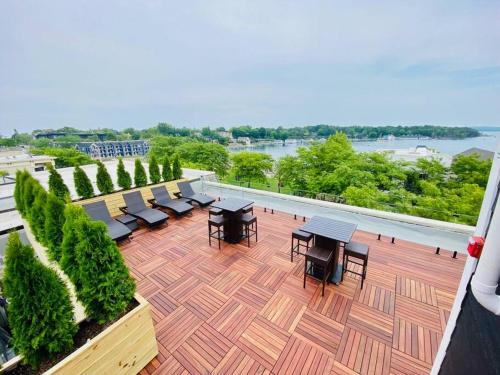 a patio with tables and chairs on a balcony at Unit B, The Kroger Lofts in Charlevoix
