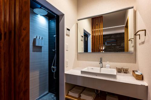 a bathroom with a sink and a mirror at SAUNA VILLA 然 in Nagano