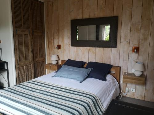 une chambre avec un lit et un miroir au mur dans l'établissement L'Escale Océane, à Labenne