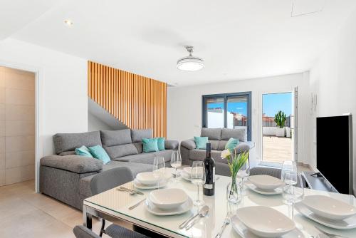 una sala de estar con una mesa y un sofá en MEDANO4YOU La Terraza del Sol, en El Médano