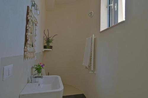 a white bathroom with a sink and a mirror at Villa Vendicari in Casa Maccari