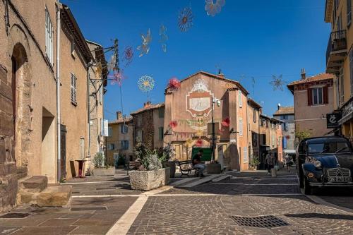 une ruelle dans une ville avec une voiture garée dans la rue dans l'établissement Charmant Studio au Village, à Roquebrune-sur Argens