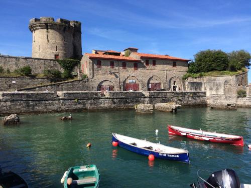three boats in the water in front of a castle at Marie-Pierre in Ciboure