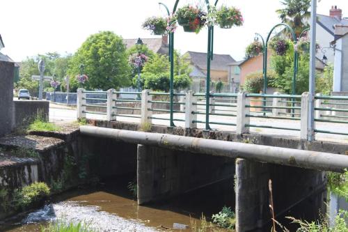 a bridge over a river with a white fence at Maison individuelle in Ossun