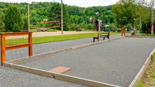 a park with two benches and a playground at Royal Laurentien in Mont-Blanc