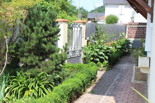 a garden with a white fence and a brick path at Maison individuelle in Ossun