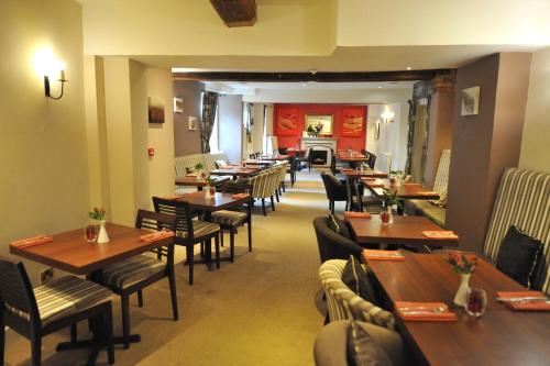 a dining room with wooden tables and chairs at The Greyhound Coaching Inn in Lutterworth