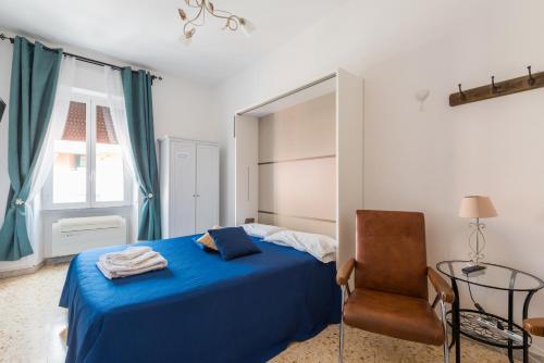 a bedroom with a blue bed and a chair at Casa Via Cesena in Rome