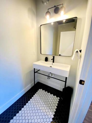 a bathroom with a white sink and a mirror at Unit C, The Kroger Lofts in Charlevoix
