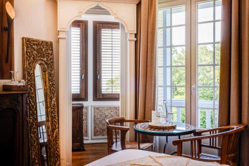 a room with a table and chairs and windows at Château des Avenieres in Cruseilles
