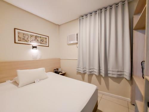 a white room with a bed and a window at Hotel Itamarati Centro-República in Sao Paulo