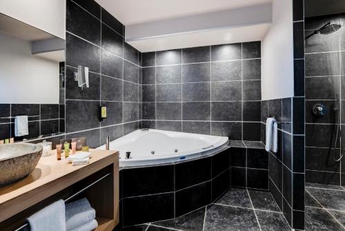 a bathroom with a tub and a sink at Château des Avenieres in Cruseilles