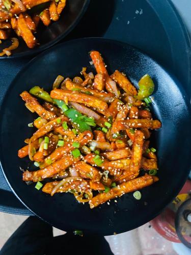 a frying pan filled with stir fried carrots and vegetables at Yashvrinda in Mandor