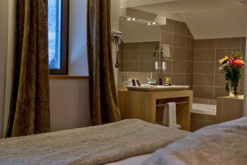 a bathroom with a bed and a sink and a tub at Château des Avenieres in Cruseilles