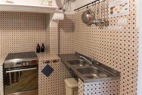 a small kitchen with a sink and a stove at La casa del Geologo in Stromboli