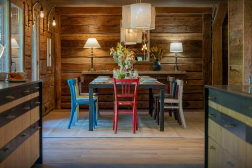 une salle à manger avec une table et des chaises colorées dans l'établissement Chalet Saint Joseph - OVO Network, à Manigod