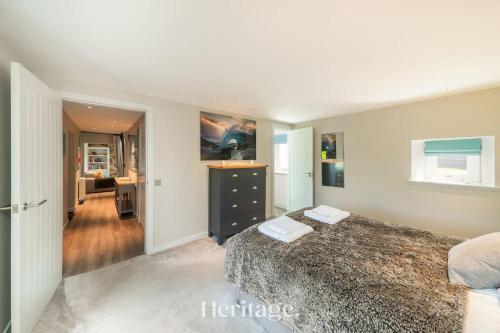 a bedroom with a bed and a dresser in it at Beach Cottage, Pet & Family Friendly Stay in Moray in Lossiemouth